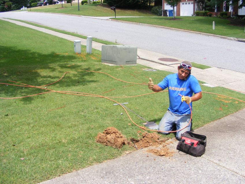 The cable man working on pulling the cable through the tunnel under the driveway